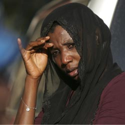 امرأة من هاييتي تراقب جثّة جنديّ من الأمم المتحدة (ب. لينسلي ـ أ ب)