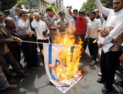 إيرانيّون يحرقون علمي الولايات المتحدة وإسرائيل تضامناً مع فلسطين والعراق في طهران أمس (بهروز مهري ـ أ ف ب)