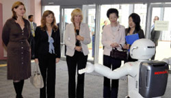 رجل آلي يستقبل نساء زعماء «الثماني» في المركز الإعلامي في هوكايدو أمس (رويترز)