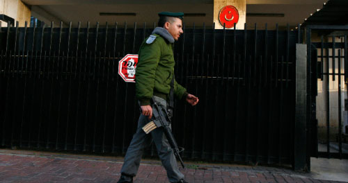 ضابط اسرائيلي يقف خارج السفارة التركية في تل أبيب أول من أمس (غيل كوهين ماغين - رويترز)