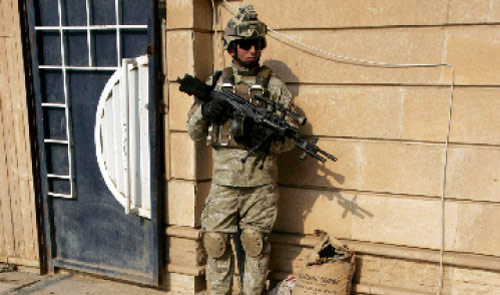 جندي أميركي أمام أكياس من المتفجّرات عثر عليها في أحد منازل بغداد (باسم شاتي ــ رويترز)