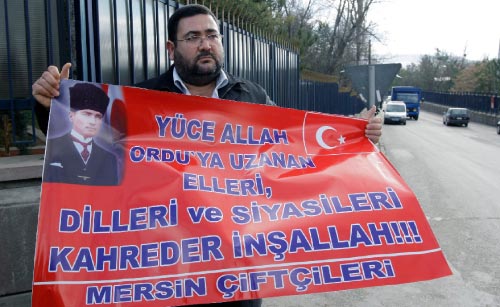 مزارع تركي يرفع لافتة تدافع عن الجيش ضد محاكمات ضباطه (برهان أوزبيليشي ـــ أ ب)