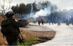 جندي للاحتلال يطلق قنابل غازية على متظاهرين ضد الاستيطان في الضفة الأسبوع الماضي (عباس موماني ـ أ ف ب)