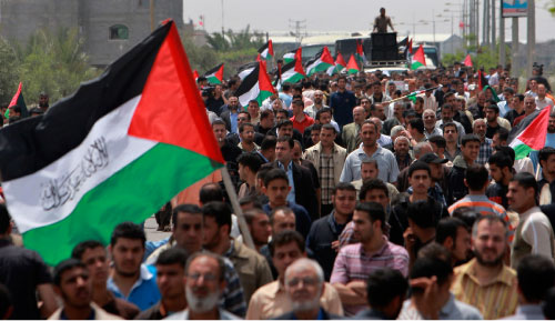 فلسطينيون يشاركون في تظاهرة احتجاجاً على القرار العسكري الإسرائيلي في غزة أمس (عادل حنّا - أ ب)