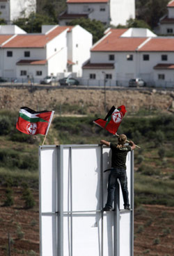 يرفع العلم الفلسطني وعلم الجبهة الشعبية لتحرير فلسطين في مقابل مستوطنة حلميش في الضفة الغربية (عباس موماني - أ ف ب ) 