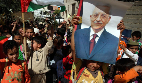 أطفال فلسطينيون يحملون صور عباس وأغصان زيتون خلال تظاهرة في نابلس أمس (ناصر اشتايه ــ أ ب)