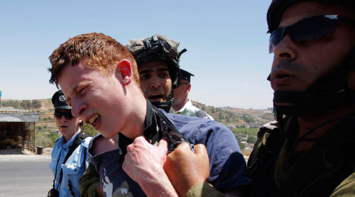 جنود إسرائيليون يعتقلون الناشط البريطاني جايمي كوري بعد مشاركته في تظاهرة احتجاج ضدّ قرصنة «رايتشل كوري» (ناصر شيوخي ــ أ ب)