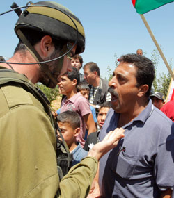 فلسطيني يتجادل وجندي إسرائيلي خلال تظاهرة في الخليل أول من أمس (ناصر شيوخي ــ أ ب)