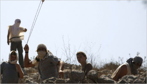 مستوطنون خلال الاعتداء على قرية كفر بورين في الضفة الغربية أمس (جعفر عشيتيه - أ ف ب)