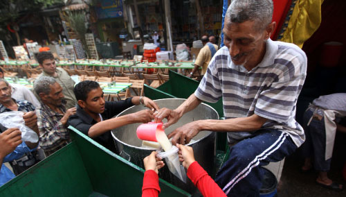 رجل مصري يوزّع عصيراً على الصائمين مجاناً الأربعاء الماضي (خالد دسوقي ــ  أ ف ب)