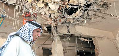 عراقي يبحث في ركام منزله الذي دمره القصف بالصواريخ أول من أمس في بغداد (أ ف ب)