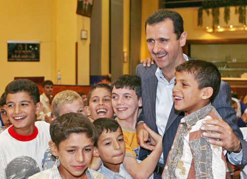 الأسد مع أطفال خلال إفطار للايتام في حلب أمس (رويترز)