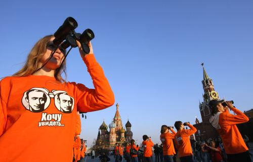 أعضاء في نادي المعجبين ببوتين أثناء نشاط في الساحة الحمراء في موسكو أمس (دينيس سينياكوف - رويترز)