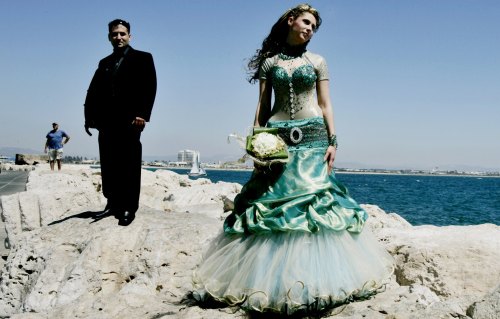 فلسطينيّان من الـ 48 خلال حفل زواجهما على شاطئ عكّا القديمة أمس (إليان أبونتيه - رويترز)