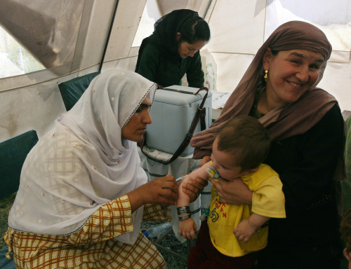 أفغانية تلقّح ابنتها في كابول أمس (مصادق صادق - أ ب)