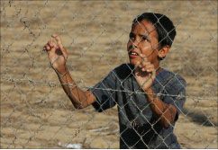 فتى فلسطيني يقف خلف سياج في غزة أمس (محمد عبد - أ ف ب)