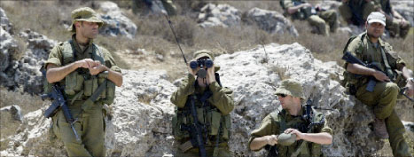 جنود إسرائيليون يراقبون تظاهرة لناشطي السلام في بيت لحم أمس (موسى الشاعر - أ ف ب)