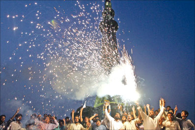 مناصرون لنوّاز شريف يحتفلون في لاهور بإعلانه عودته قريباً إلى باسكتان أمس (عريف علي - أ ف ب)