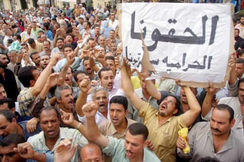 عمال مصنع الغزل خلال تظاهرهم لليوم الرابع في المحلة (شمال القاهرة) أمس (إي بي آي)