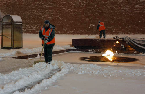 عاملا بلدية يزيحان الثلج عن نصب الجندي المجهول في موسكو أمس (ألكسندر زيمليتنشكو - أ ب)