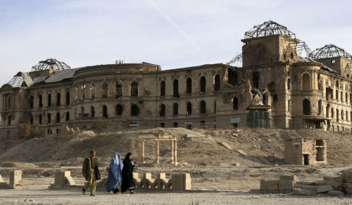 أفغان يمرّون أمام أنقاض القصر الملكي في كابول أمس (رحمت غول - أ ب)