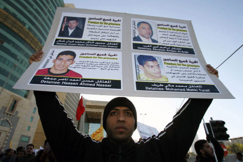 متظاهر بحريني يحمل صورة معتقلين خلال تظاهرة في المنامة أمس (آدم جان ــ أ ف ب)