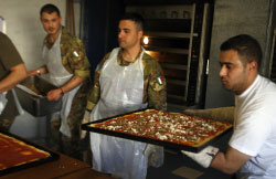 جنود إيطاليّون من الـ«يونيفيل» يحضّرون البيتزا لمُقعدين لبنانيّين في صور (رمزي حيدر ـ أ ف ب)