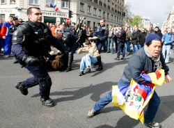 رجال شرطة فرنسيون يوقفون متظاهرين مناهضين للصين خلال مسيرة الشعلة الأولمبية في باريس أمس (جاك برينو - أ ب)