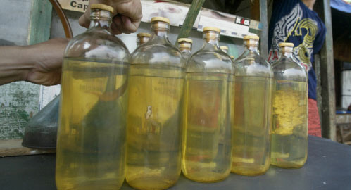 بيع الوقود بالمفرّق داخل زجاجات في شوارع أندونيسيا (أروين فدريانسيا - أ ب)
