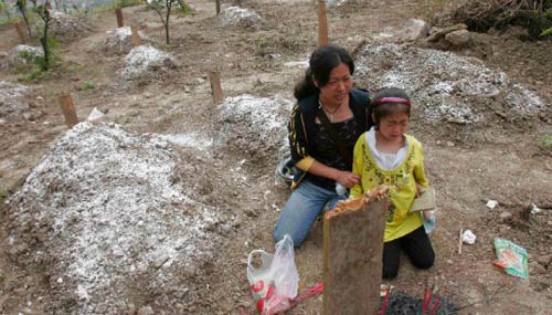 صينية وإبنتها يبكون ربّ الأسرة الذي قتل في الزلزال في مقاطعة سيشوان أمس (سترينغر- رويترز)