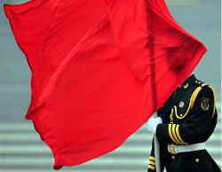 العلم الصيني يغطّي وجه أحد عناصر فرقة التشريفات خلال استقبال ميدفيديف في بكين أمس (تيه إنغ كون ـــ أ ف ب)