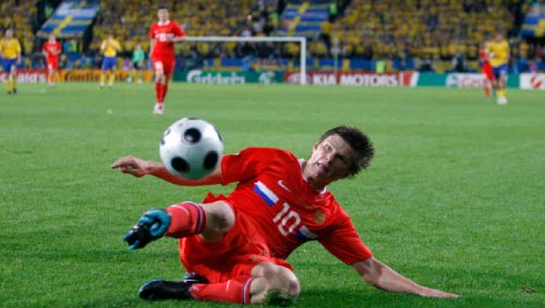 الروسي أندريه أرشافين زاحفاً نحو الكرة التي سجّل منها الهدف الثاني لبلاده في مرمى السويد (جون سوبر ـ أ ب)