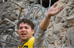 عامل إغاثة إيراني في موقع مبنى انهار في شمال طهران أمس (مرتضى بيقوبازل - رويترز)