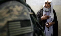 شيخ عراقي يخاطب جنديّاً للاحتلال خلال تفتيش منزله في بغداد أمس (دامير ساغولج - رويترز)