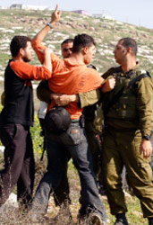 جنود اسرائيليون يعتقلون شاباً فلسطينياً في الضفة الغربية (عبد عمر قوسيني ـ رويترز)