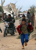 فلسطينيون يهربون من المواجهات مع الجيش الإسرائيلي في خان يونس أمس (أشرف عمرو ــ أ ب)
