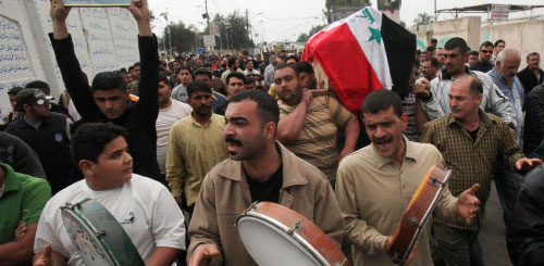 عراقيون يشيعون مناصراً لعلاوي قتل خلال الاحتفالات بفوز قائمة «العراقية» في الأعظمية (خالد محمد - أ ب)
