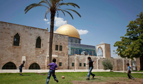 أطفال فلسطينيون يلعبون الكرة أمام قبة الصخرة في القدس المحتلة (مايا حتيج ــ أ ب)
