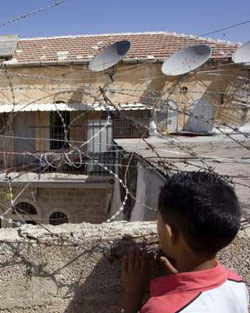 طقل ينظر إلى البيت الذي استولى عليه مستوطنون في القدس المحتلة أمس (أ. غرابلي ـ أ ف ب)