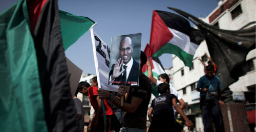 فلسطيني يحمل صورة سيف الاسلام القذافي خلال تظاهرة لدعم سفينة «الأمل» (تارا تودراس ـ أ ب)