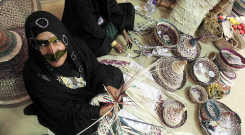 إماراتية تعرض مشغولات من النخيل في معرض التمور في أبو ظبي (كريم صاحب - أ ف ب)