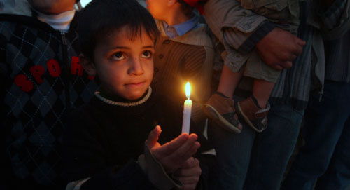 طفل فلسطيني يستذكر حرب غزة ويضيئ شمعة أمس (محمد سالم ــ رويترز) 