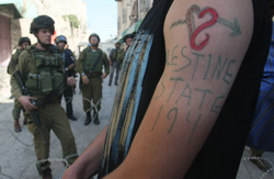 فلسطيني كتب على يديه شعار «فلسطين الدولة 194» في الضفة الغربية أمس (حازم بدر ــ أ ف ب)