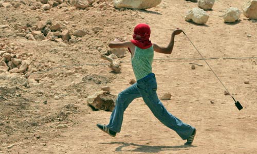طفل فلسطيني يرجم جنود الاحتلال في قرية نعلين في الضفة الغربية أمس (ناصر اشتيه ــ أ ب)
