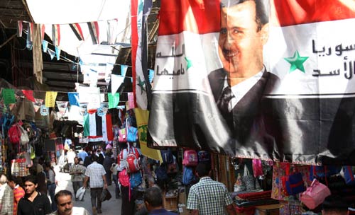 صورة الأسد مرفوعة في أحد أسواق دمشق أمس (باسم تلاوي - أ ب)