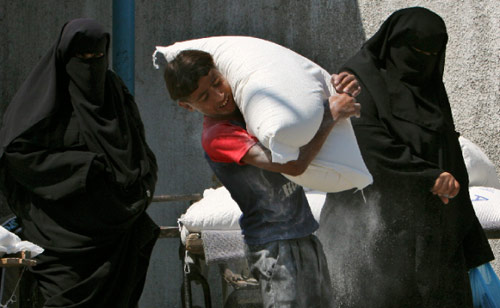 فلسطيني يحمل كيساً من الطحين من معونة الأمم المتحدة في شمال غزة أمس (عادل حنا - أ ب)