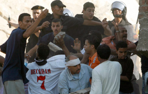 مصريّون يرشقون عناصر الشرطة بالحجارة بسبب تأخّر أعمال الإغاثة إثر انهيار الدويقة (أسماء وجيه ـــ رويترز)