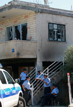 رجال شرطة إسرائيليون أمام أحد البيوت العربية المحترقة في عكا (عمرو عواد - رويترز)