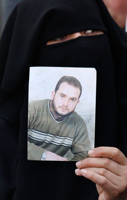 فلسطينيّة تحمل صورة أحد أقاربها المعتقل لدى سلطات الاحتلال في غزة أول من أمس (صهيب سالم ـــ رويترز)