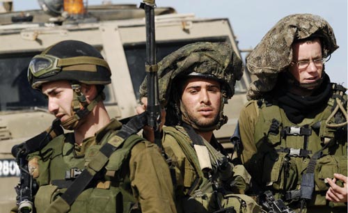 جنود إسرائيليّون في الموقع الذي قُتل فيه زميلهم عند معبر كيسوفيم على الحدود مع غزّة أمس (دافيد بويموفيتش ـــ أ ف ب)